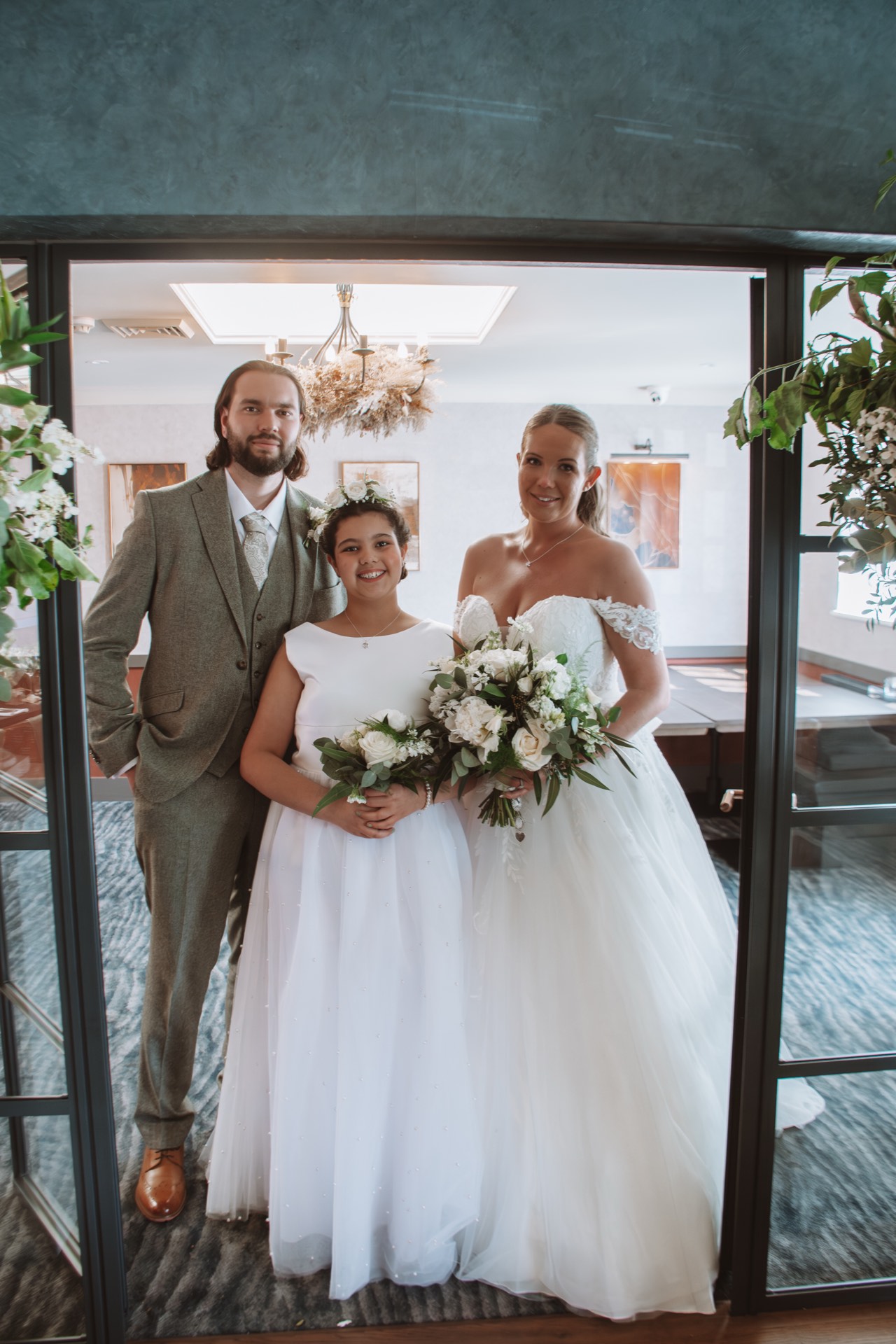 A bride and groom with a young guest