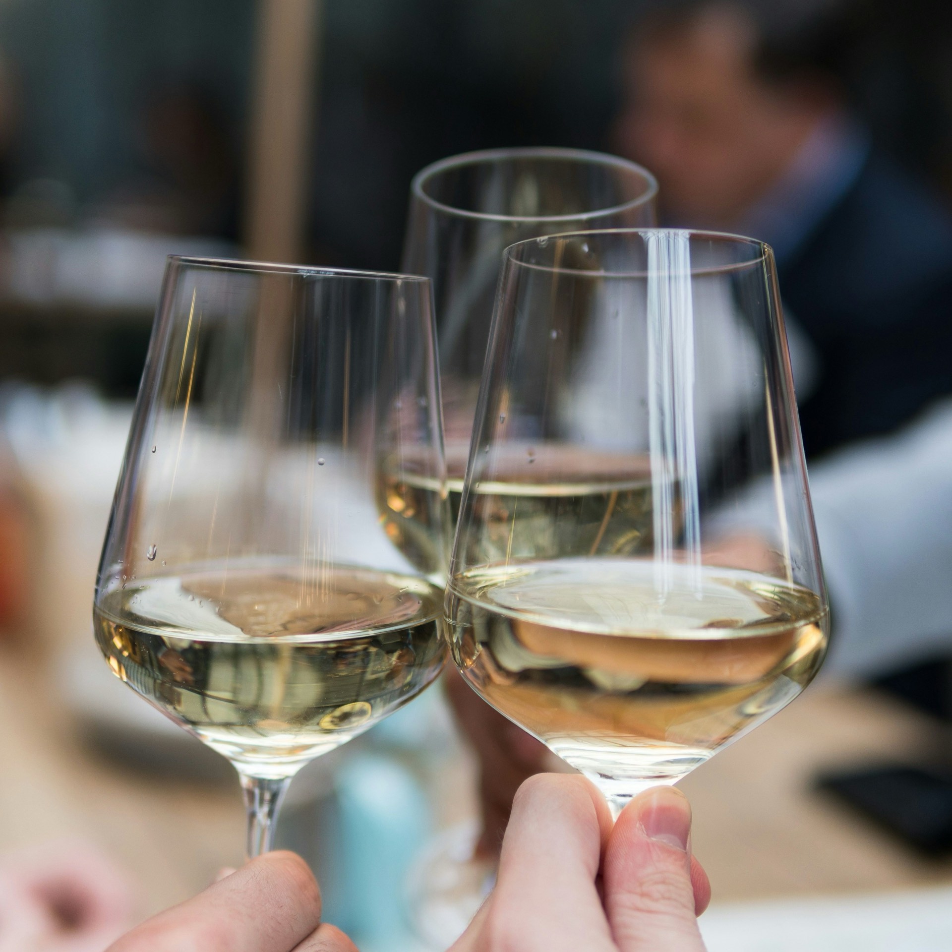 Glasses of white wine raised in a toast