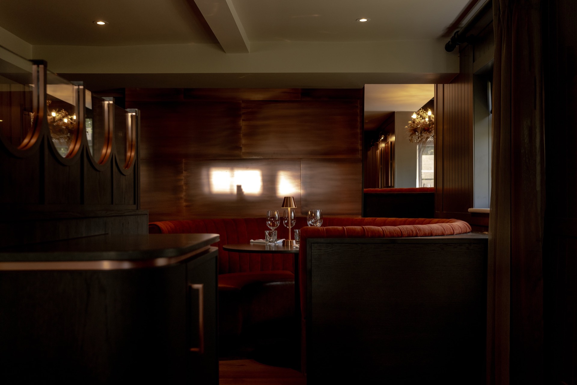 A red velvet booth set for dining