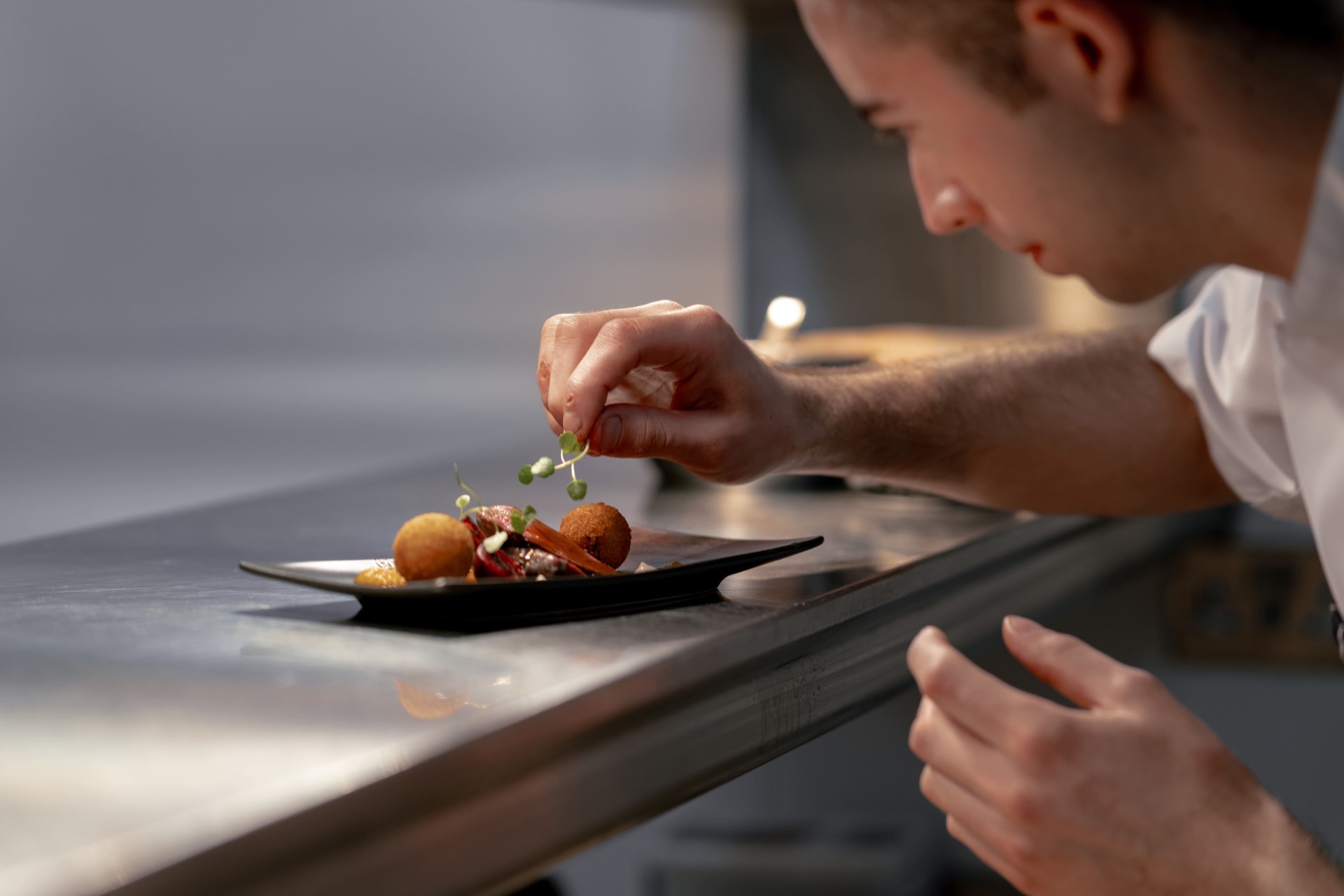 A chef preparing a dish with fresh herbs