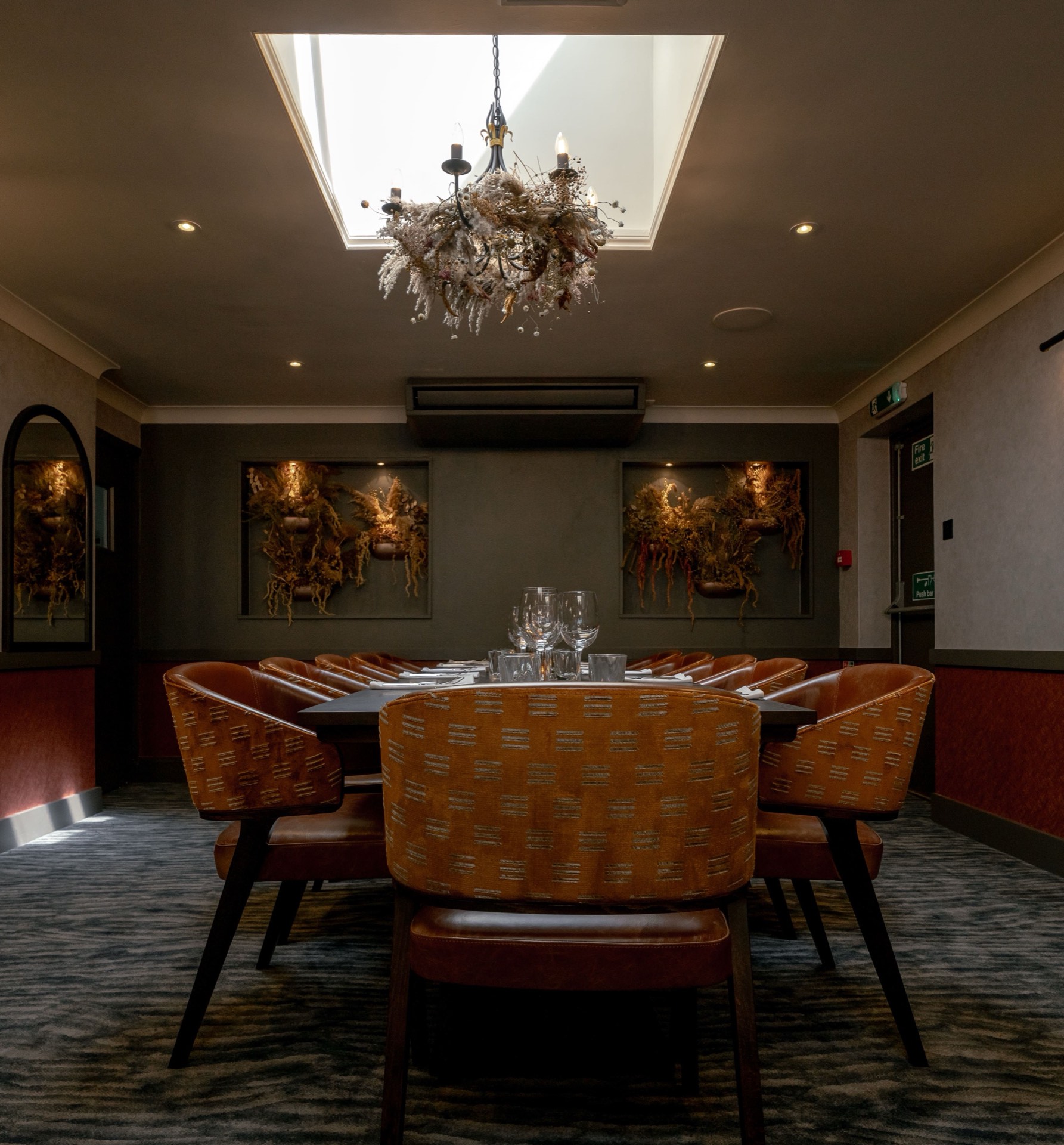The private dining room at Mason's with orange chairs, a large table and chandelier