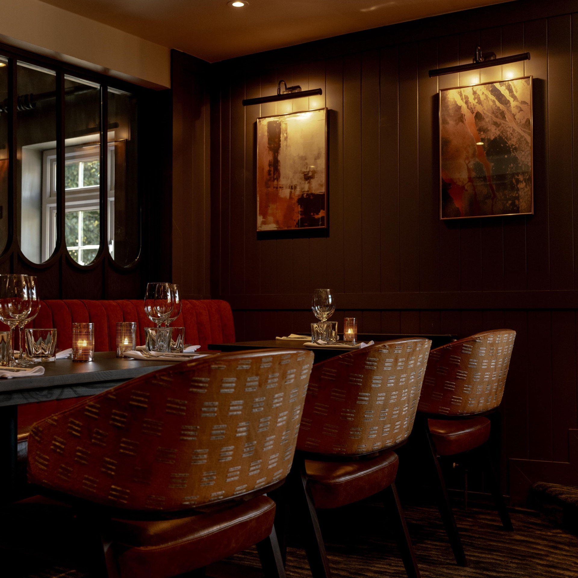 The restaurant interior with dim lighting, set tables and abstract art