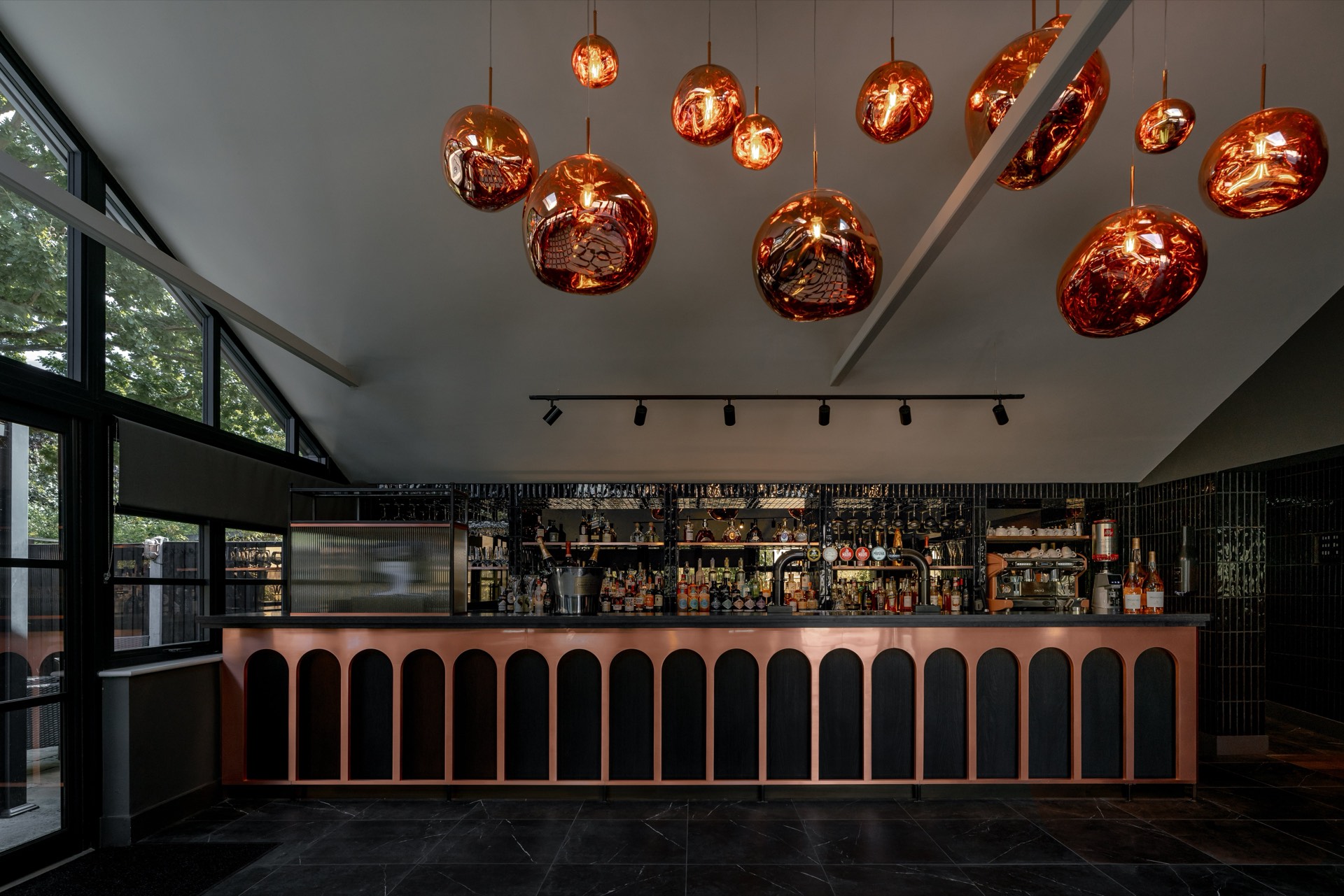 Copper pendant lights above the bar