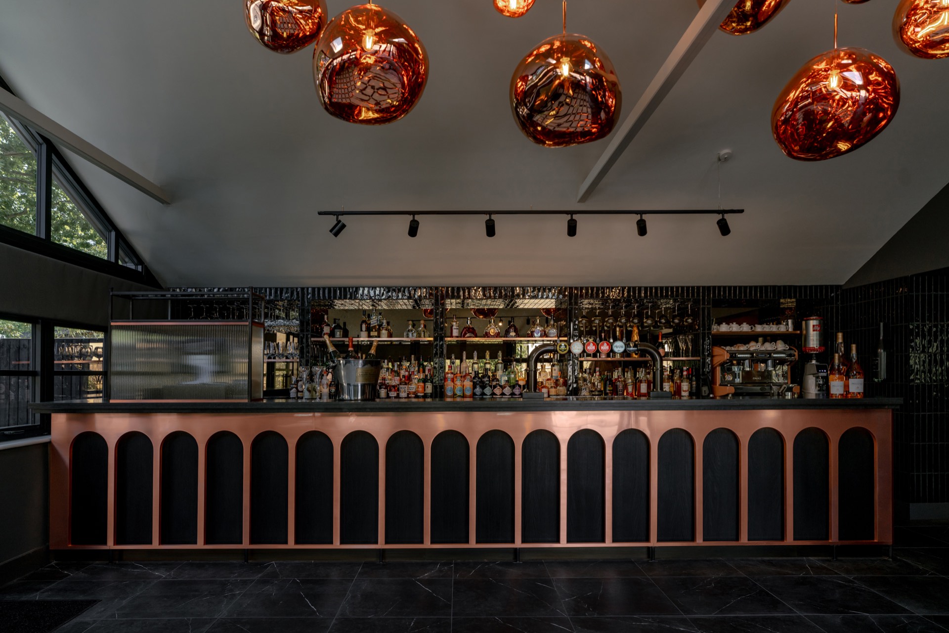 The copper-fronted bar beneath amber pendant lights
