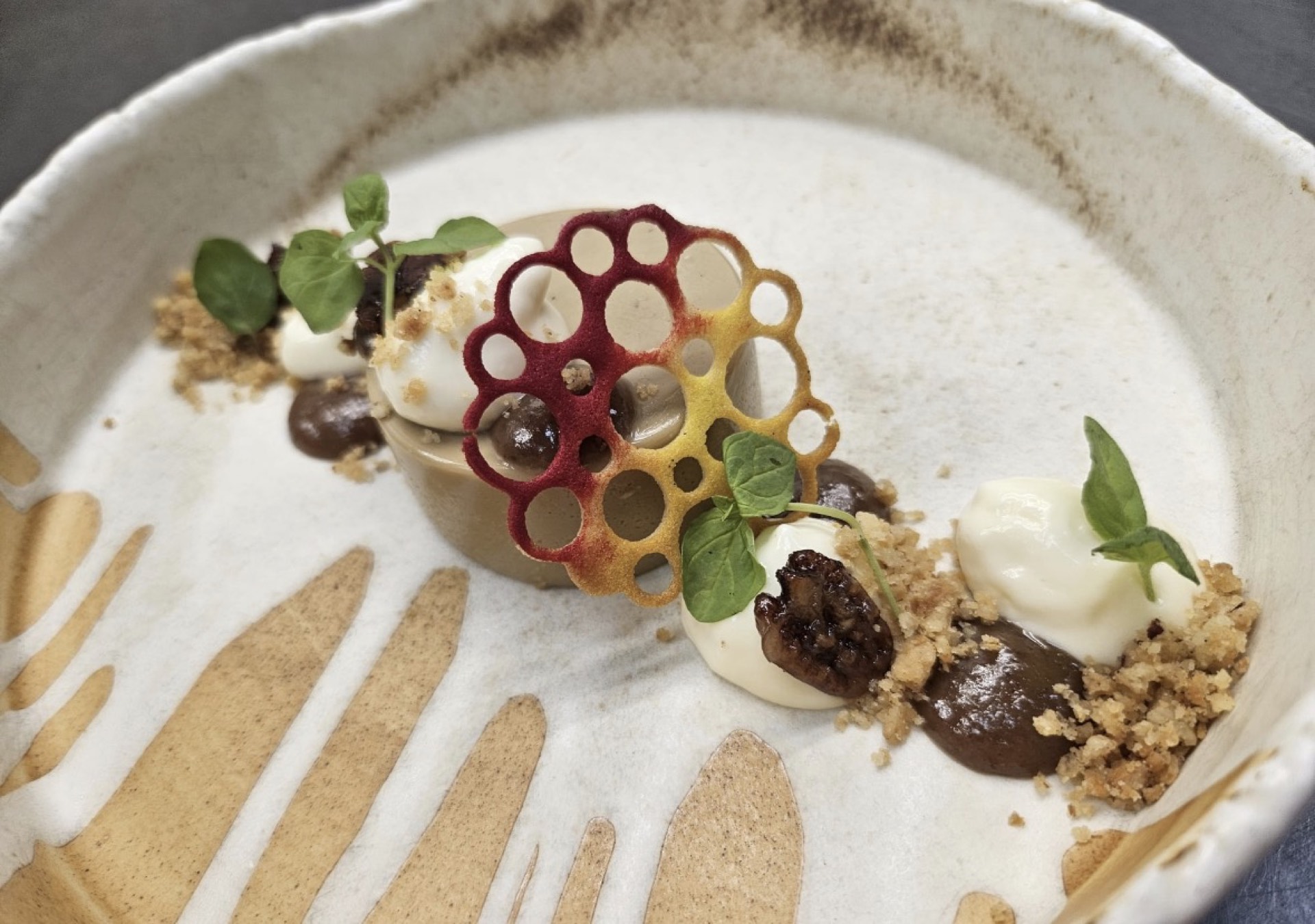 A plated dessert with berries and a honeycomb tuile at Mason's